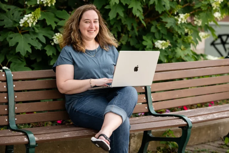 Kristen Jerry working on a laptop on a bench in Woodstock