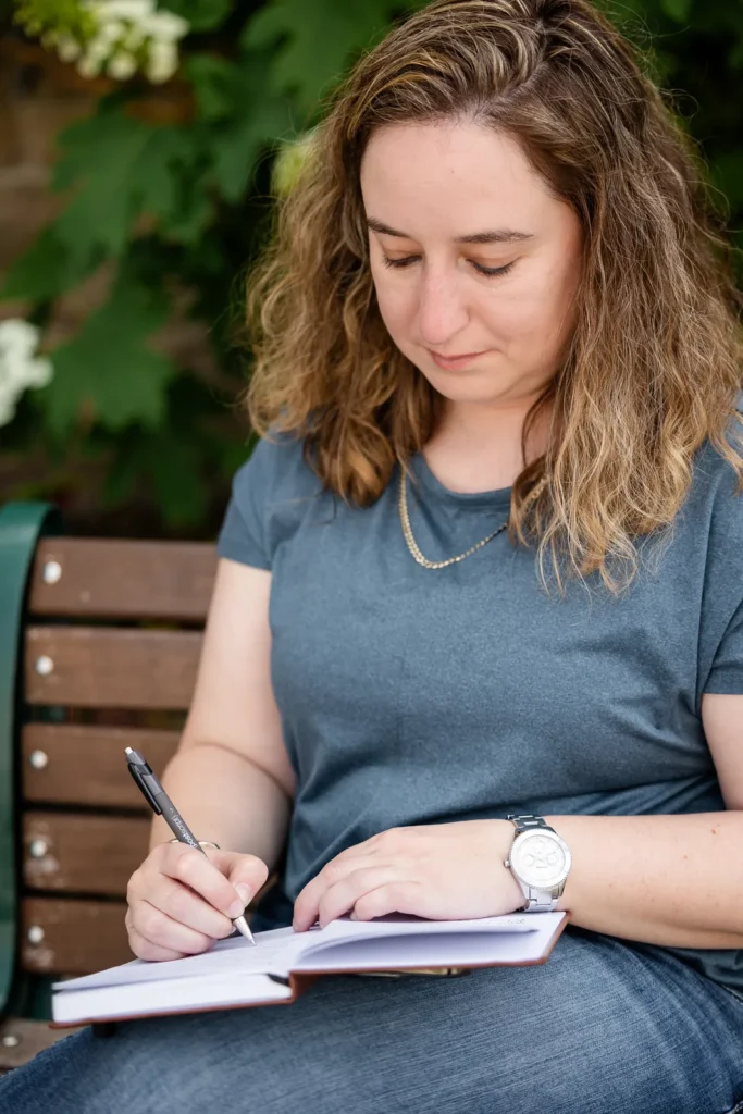 Kristen Jerry writing in a notebook on a bench