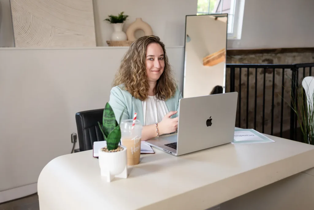 Kristen Jerry at a desk with a laptop and a plant