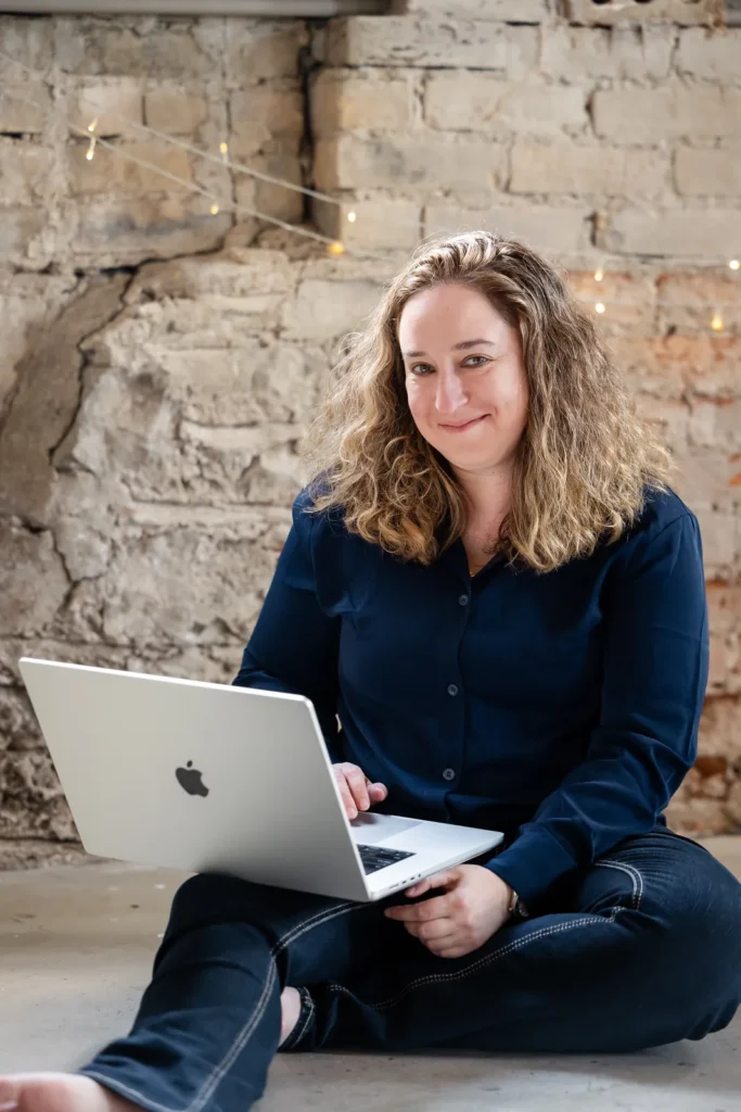 Kristen Jerry sitting on the floor with a laptop