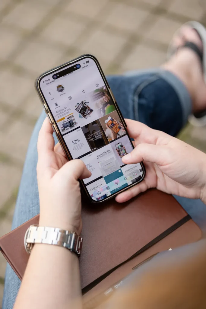 Hands holding a phone showing an Instagram profile