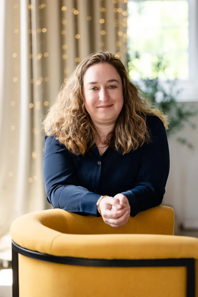 Portrait of Kristen Jerry leaning on a yellow chair